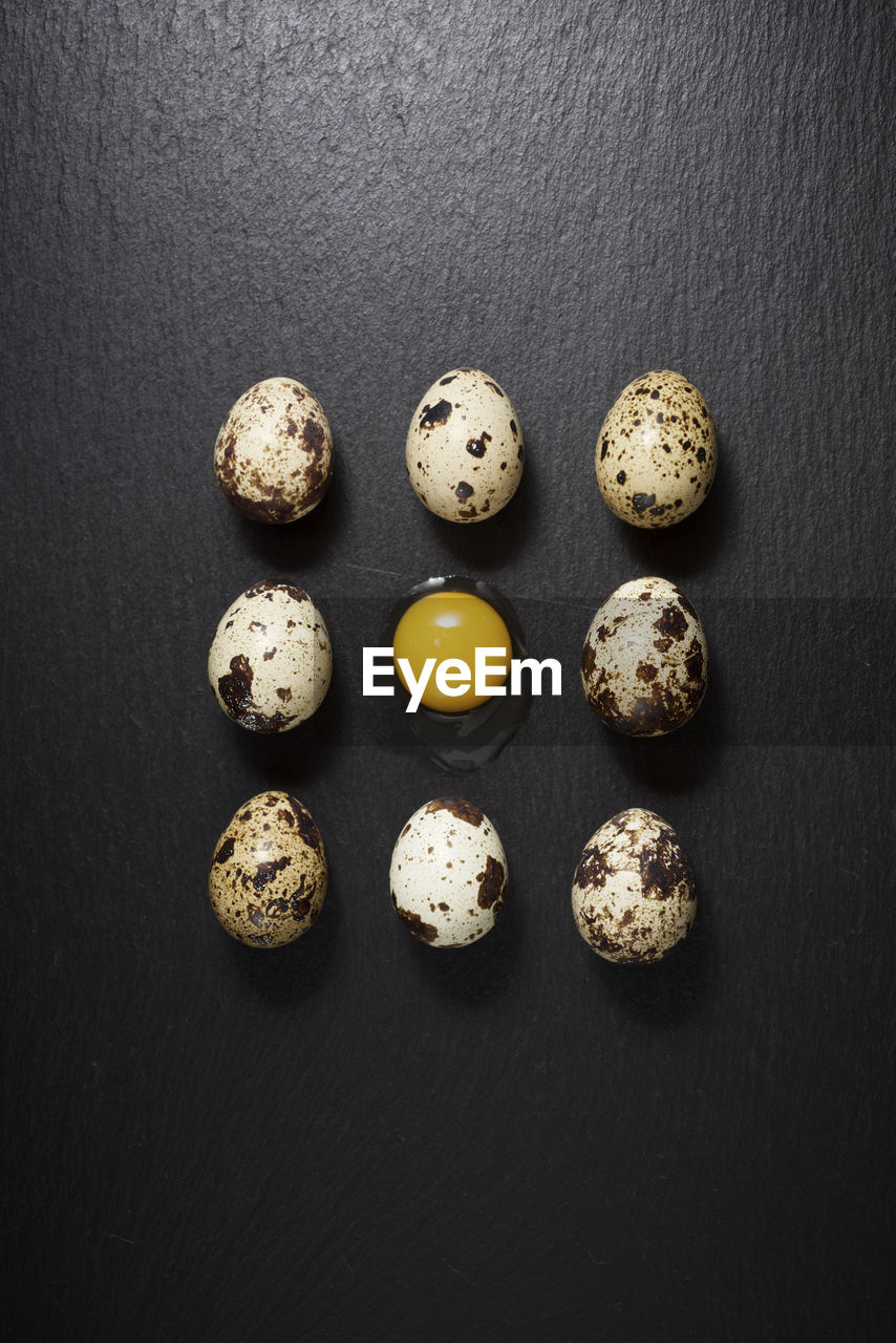 Quail eggs on a black table.