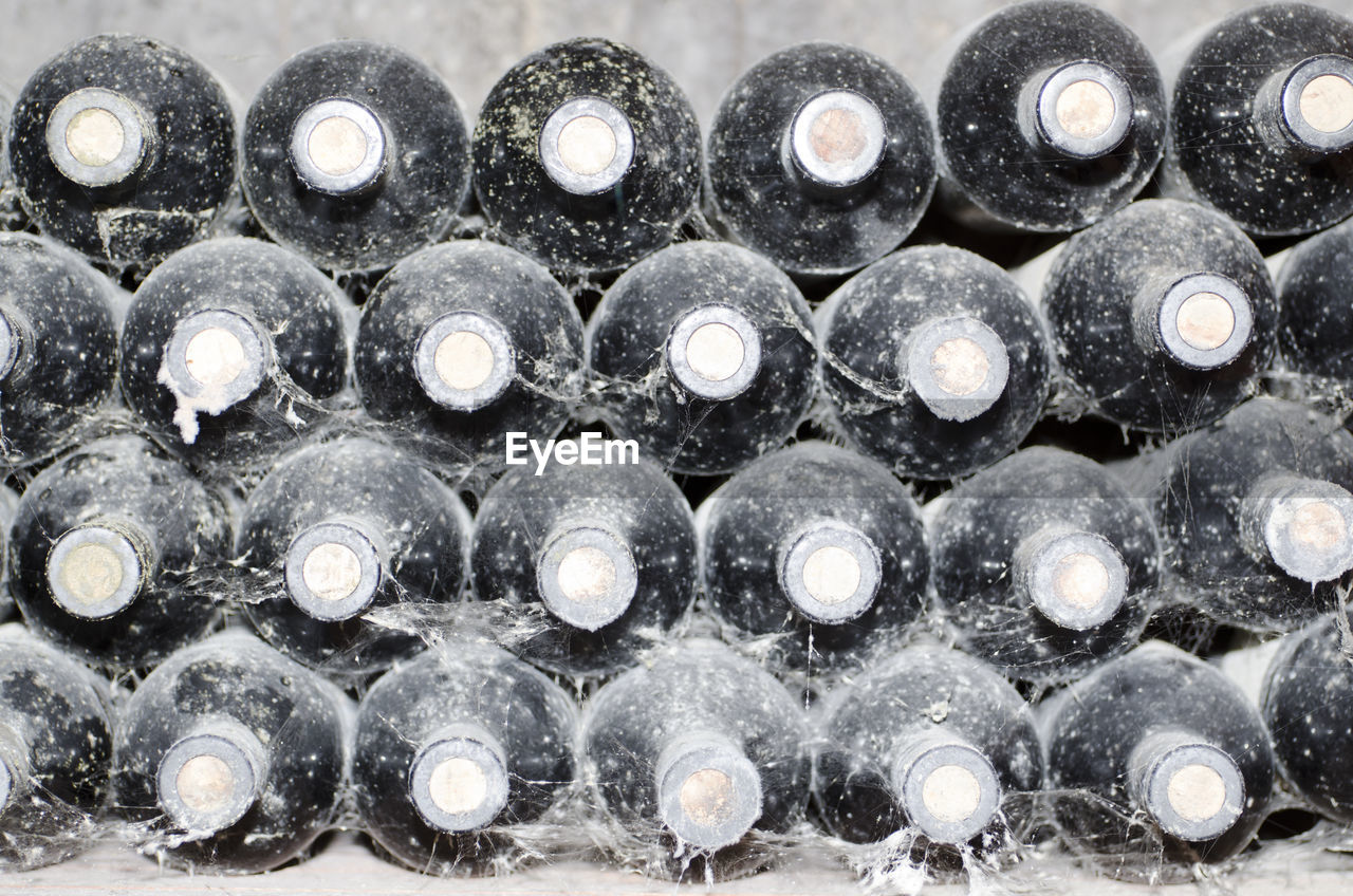 Heap of old wine bottles with dust and spider web