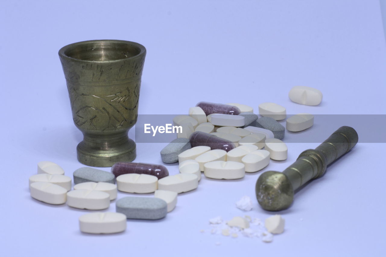 Close-up of medicines with mortar and pestle on table