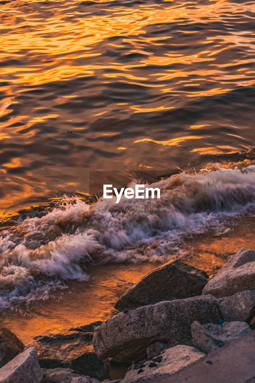 High angle view of waves in sea during sunset