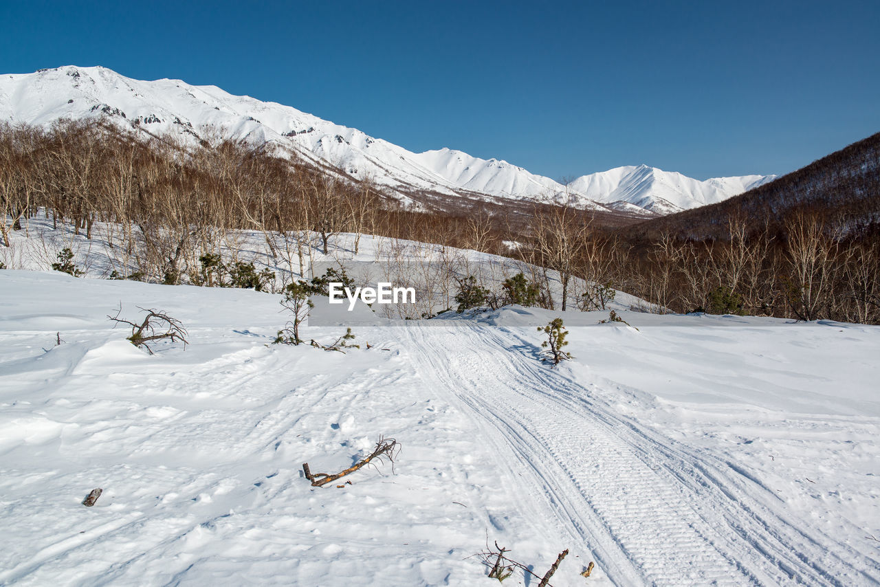 Snowcapped landscape against clear sky