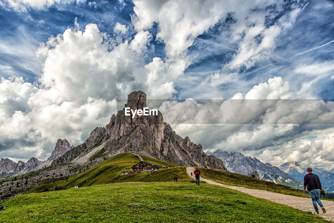 PEOPLE ON LANDSCAPE AGAINST MOUNTAINS