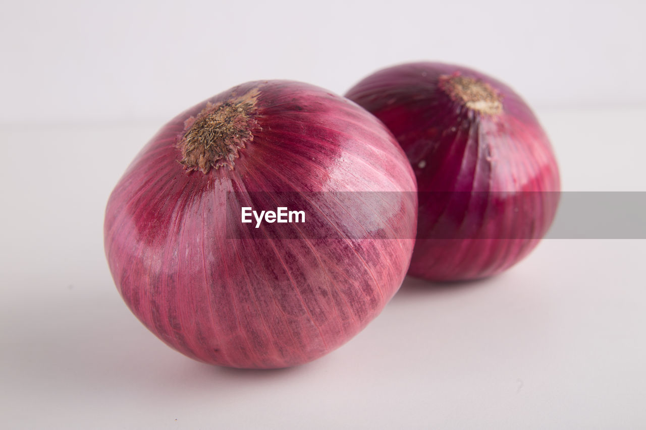 CLOSE-UP OF RED APPLE ON WHITE BACKGROUND