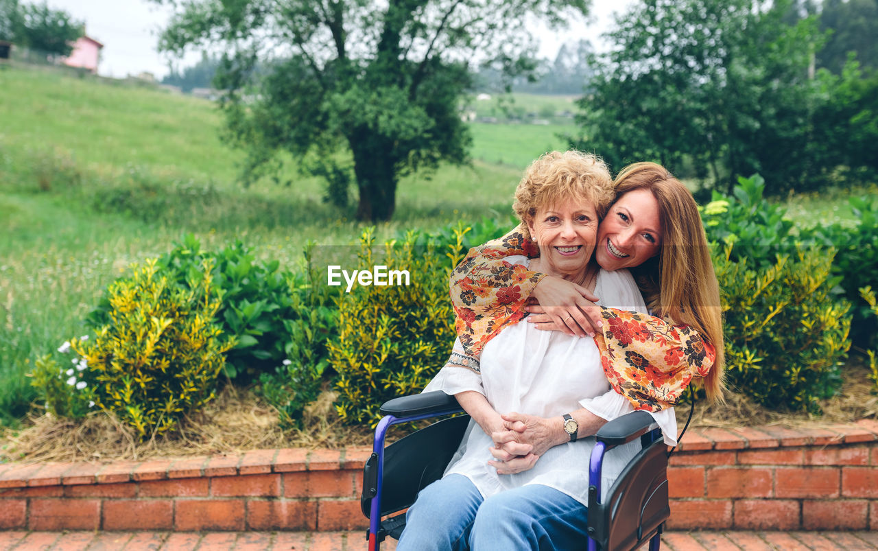 Portrait of cheerful mother and daughter in public park