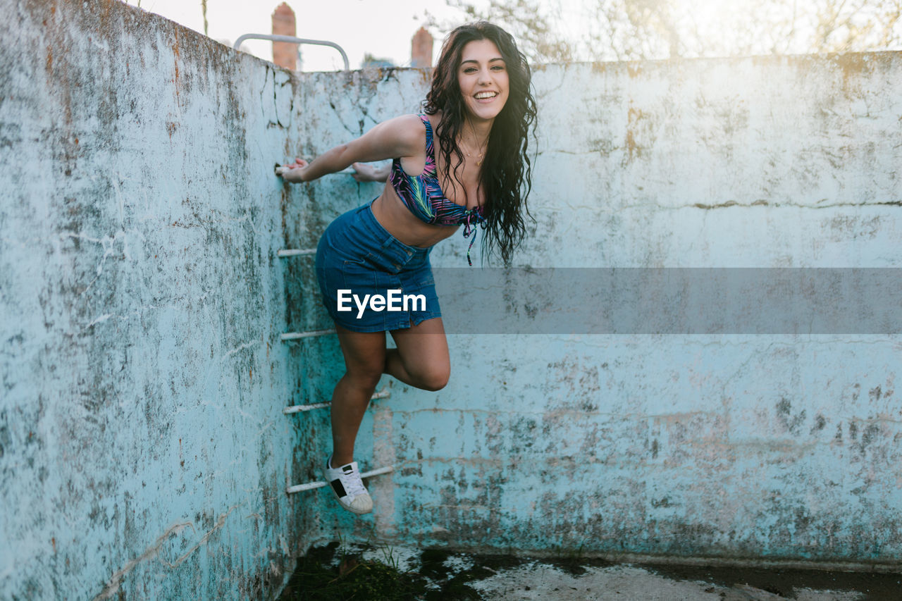 Beautiful woman standing at abandoned swimming pool