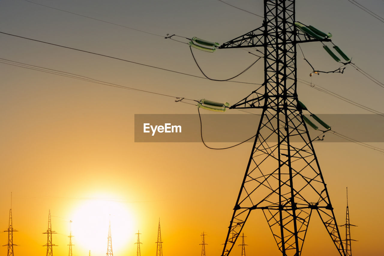 low angle view of electricity pylon against clear sky during sunset