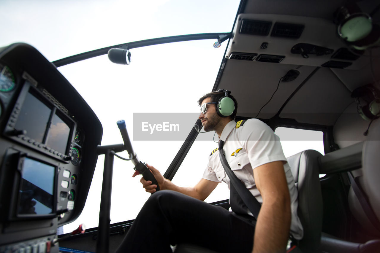 The pilot sits in the helicopter cockpit.