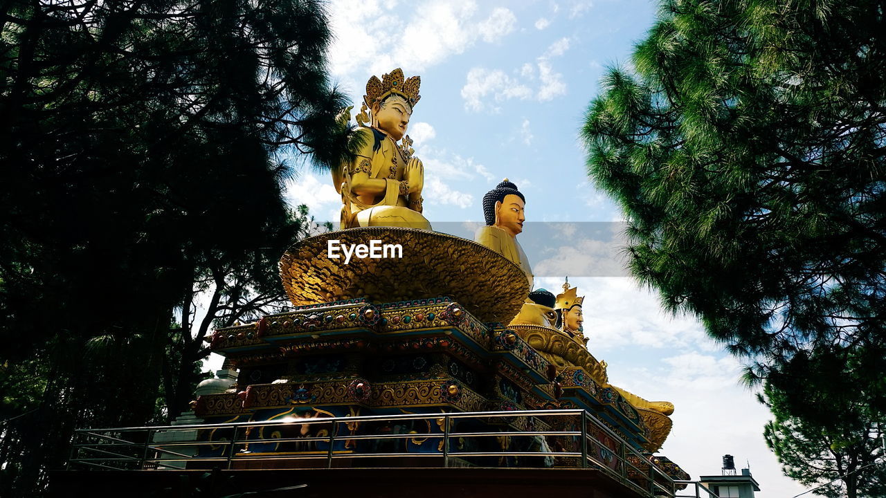 Low angle view of statues against sky at swayambhunath