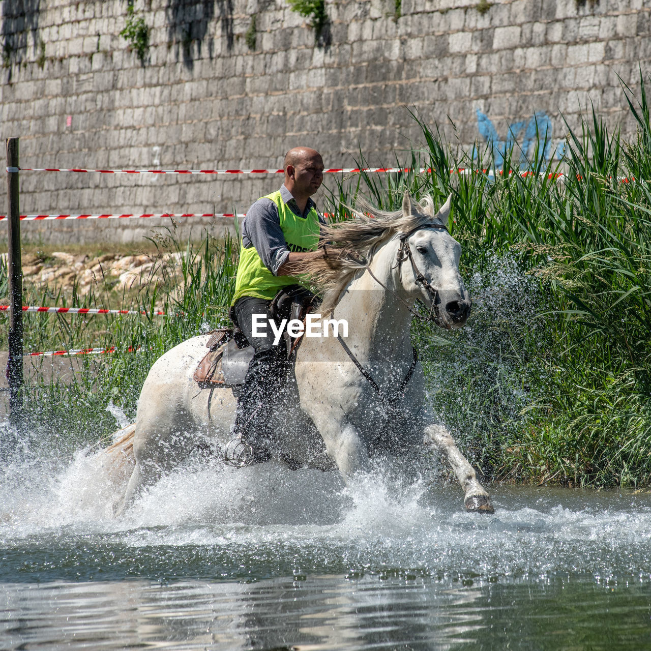 SIDE VIEW OF A MAN SPLASHING WATER IN PARK