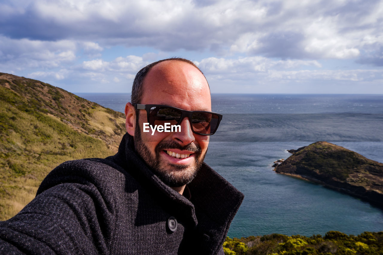 Portrait of smiling man against sea ad sky