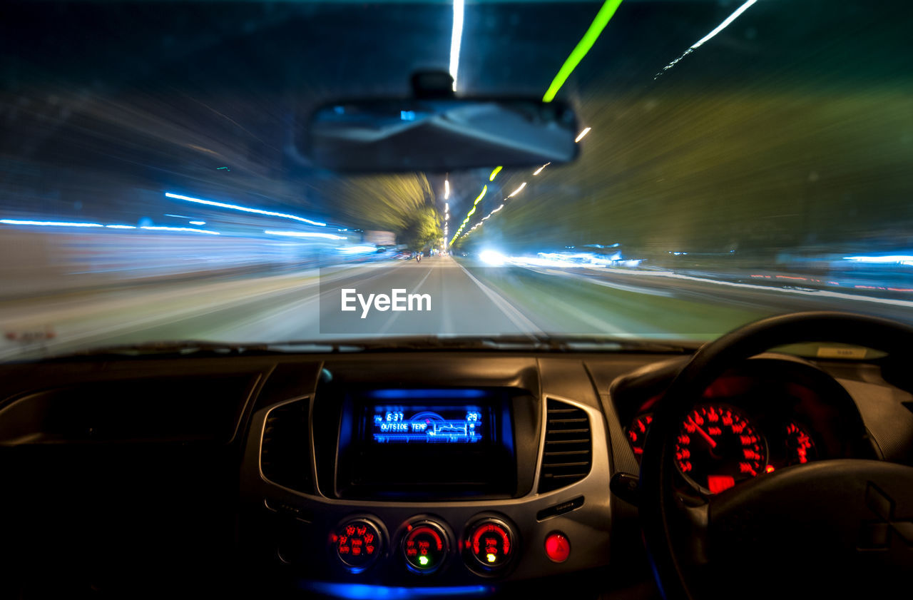 Interior of car on road against sky at night
