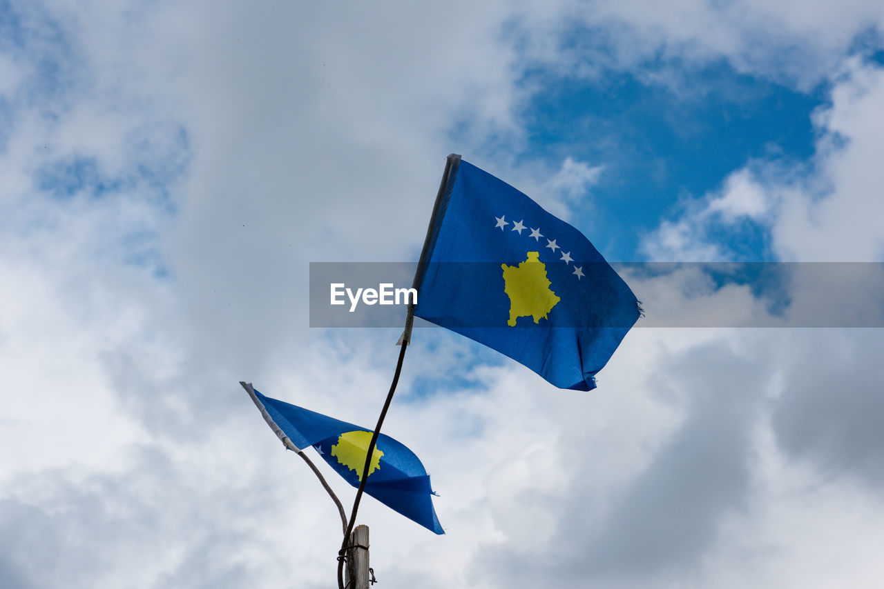 Low angle view of kosovo flag against blue sky