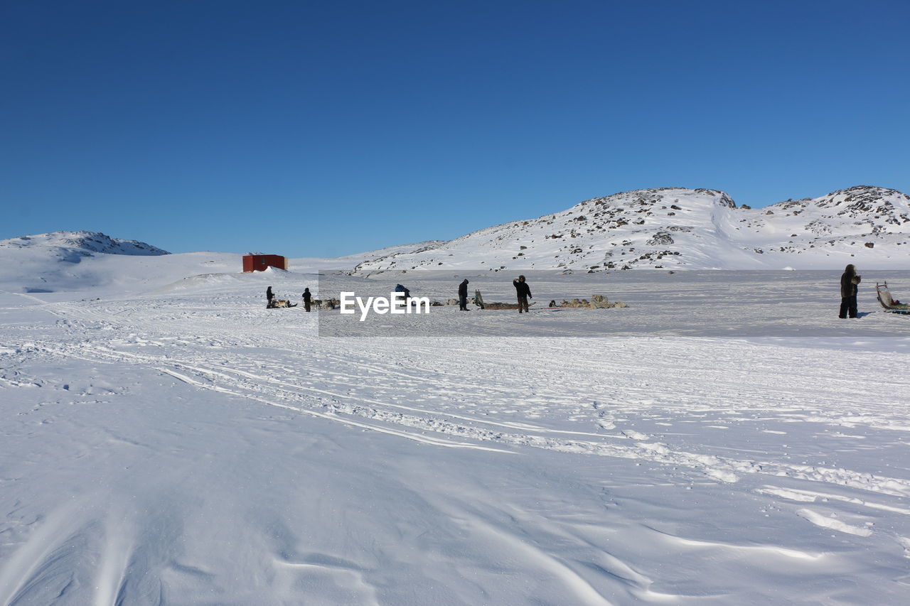 Scenic view of snowy landscape against clear blue sky