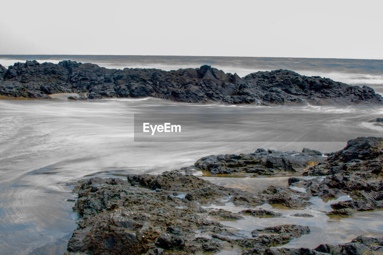 SCENIC VIEW OF ROCKS IN SEA AGAINST SKY