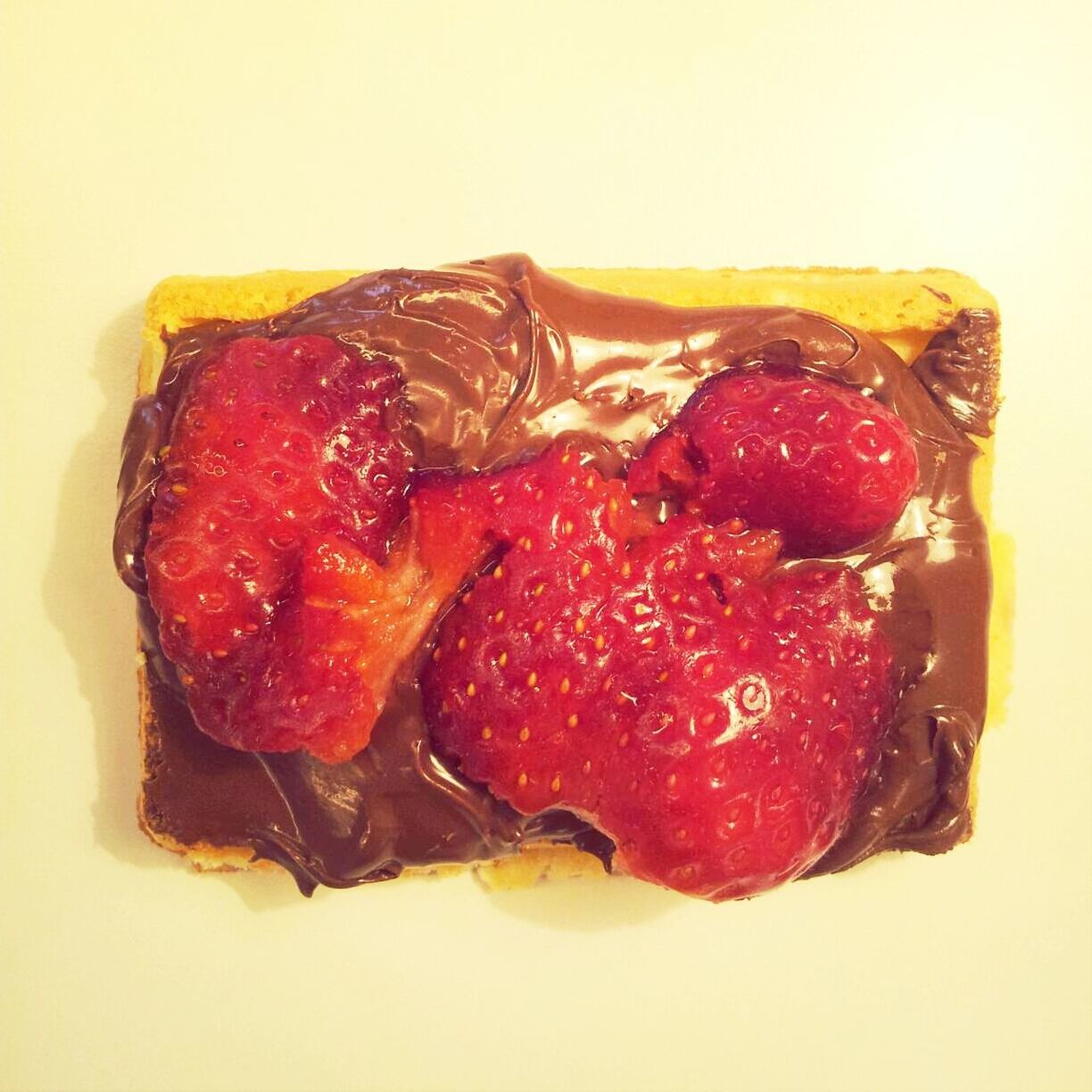 Close-up of strawberry and chocolate spread on waffle