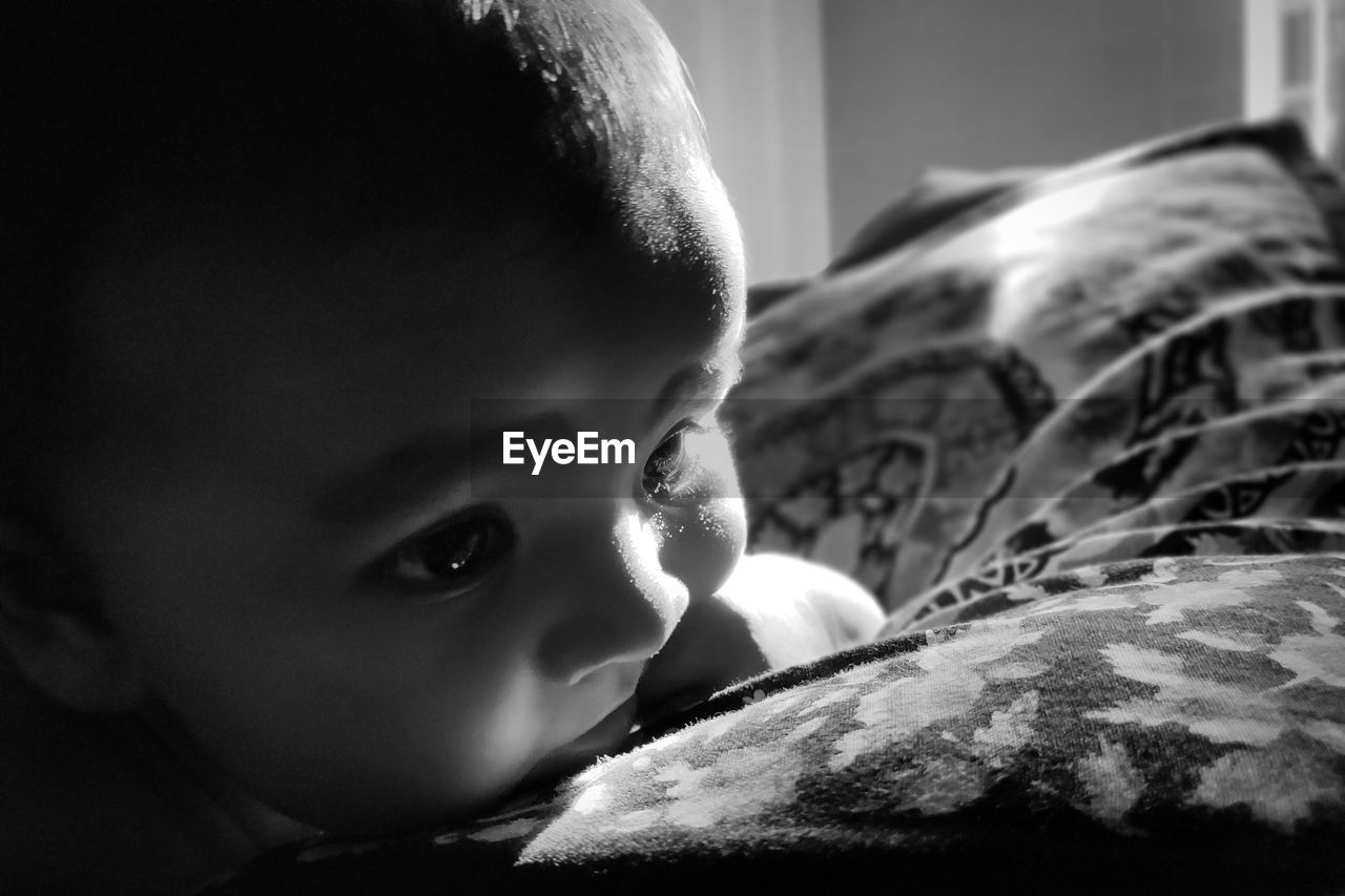 Close-up of cute baby girl on bed