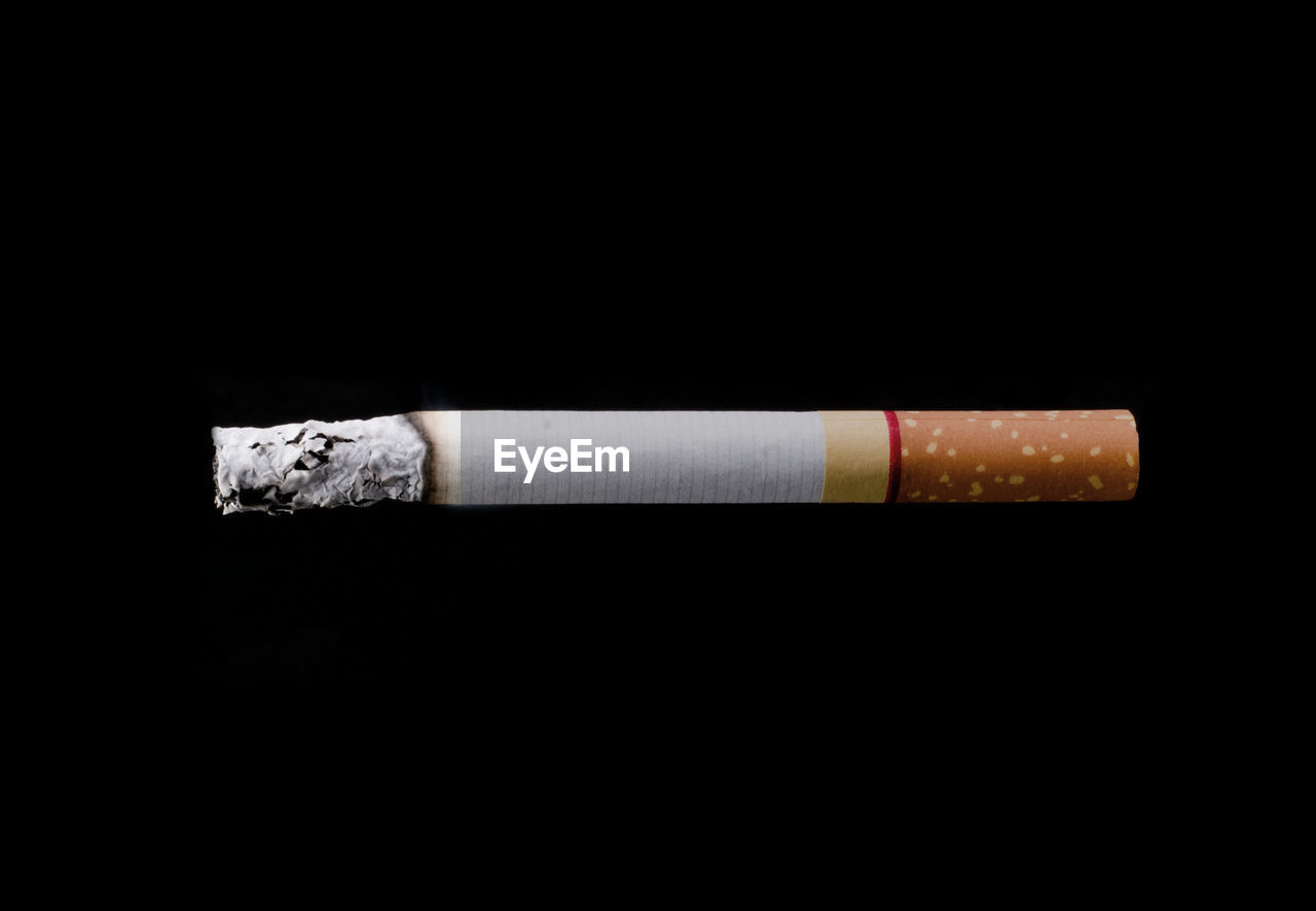 Close-up of cigarette over black background