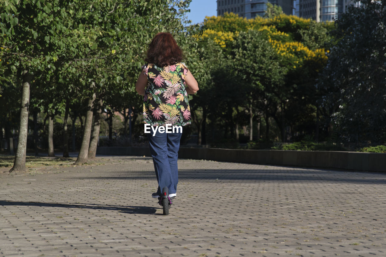 rear view of young woman walking on footpath