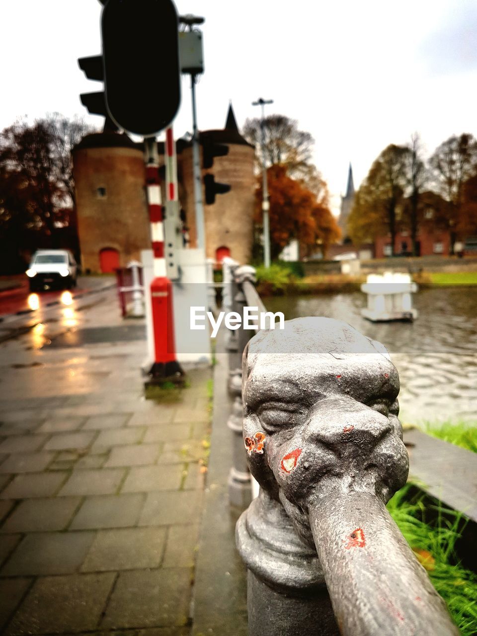 Close-up of dog head statue at edge of bridge against sky