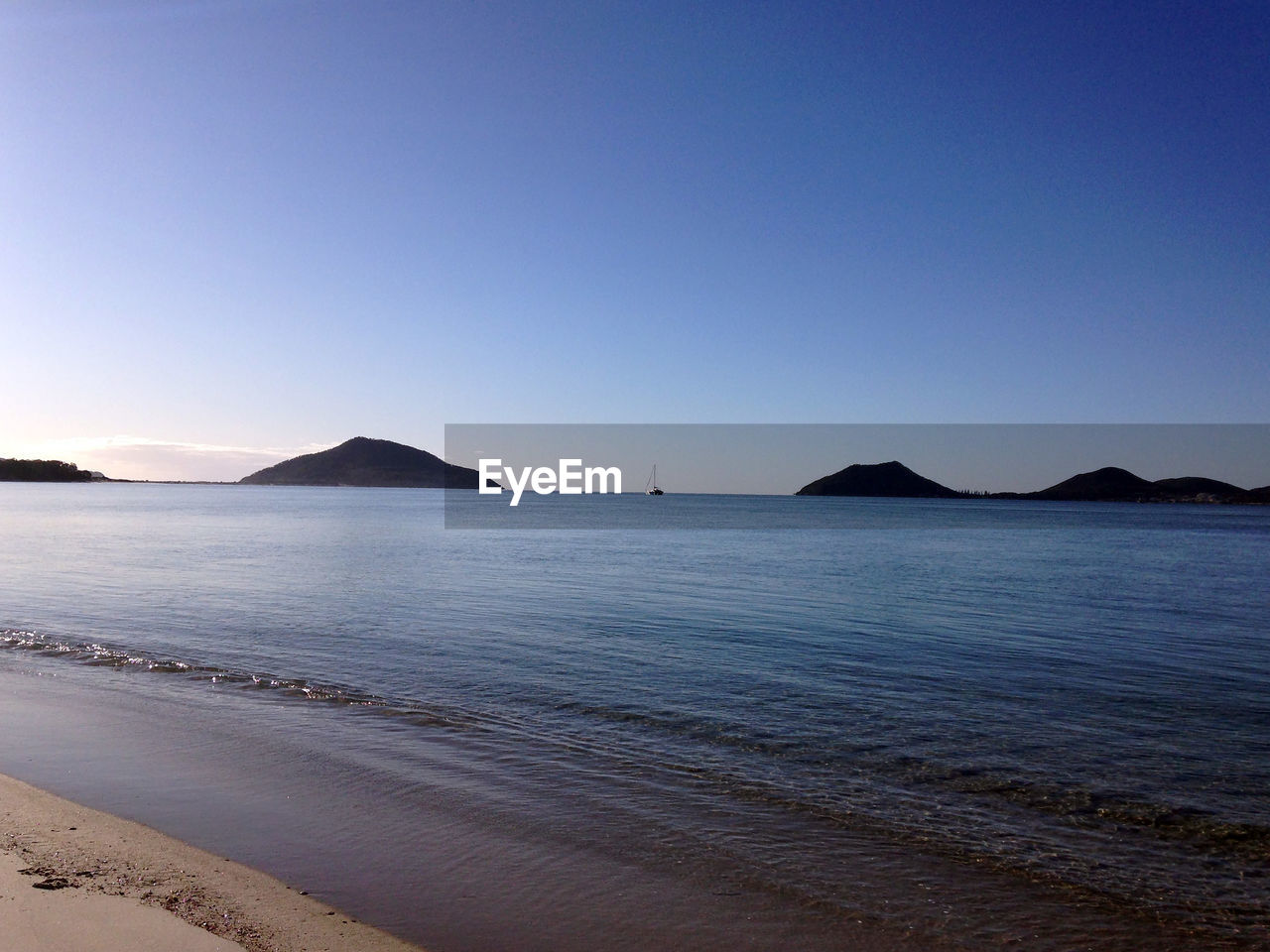 Scenic view of sea against clear blue sky