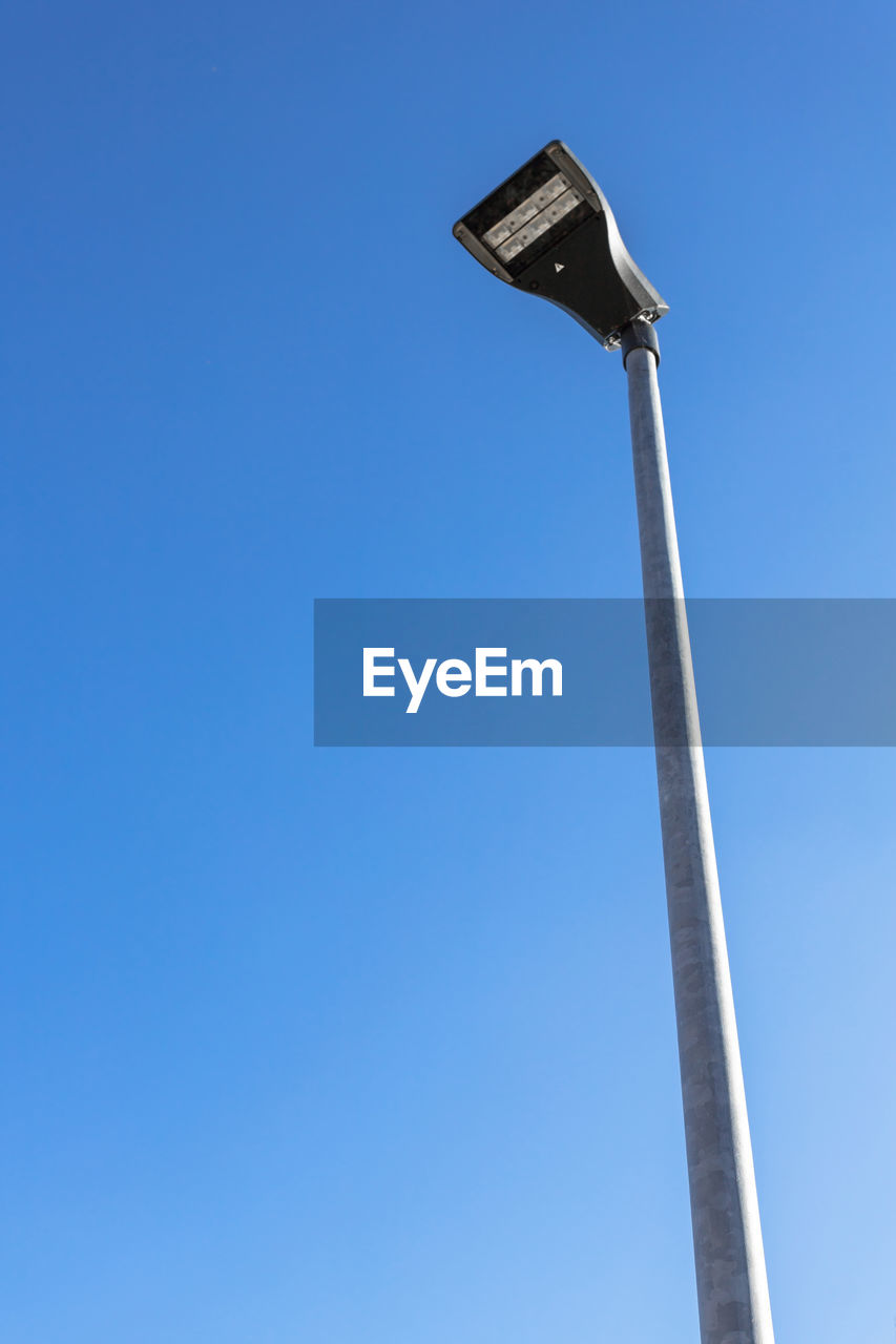 street light, sky, blue, low angle view, clear sky, light fixture, lighting, copy space, no people, mast, pole, day, lighting equipment, nature, sunny, outdoors, wind turbine, street, metal, wind