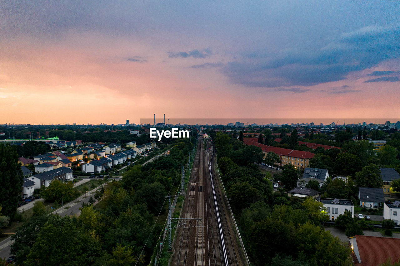 High angle view of street amidst buildings against sky during sunset