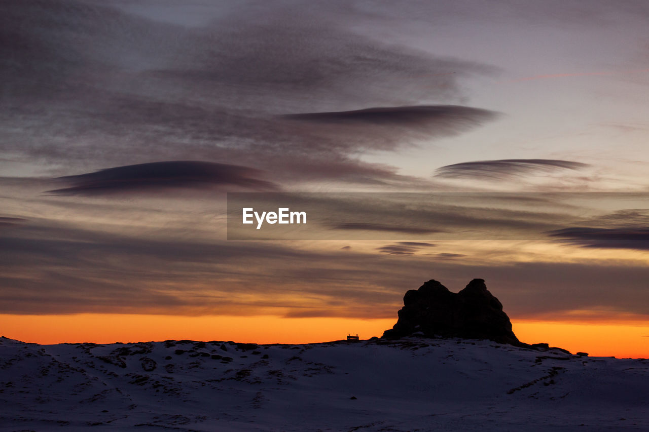 Scenic view of snowcapped mountains against sky during sunset