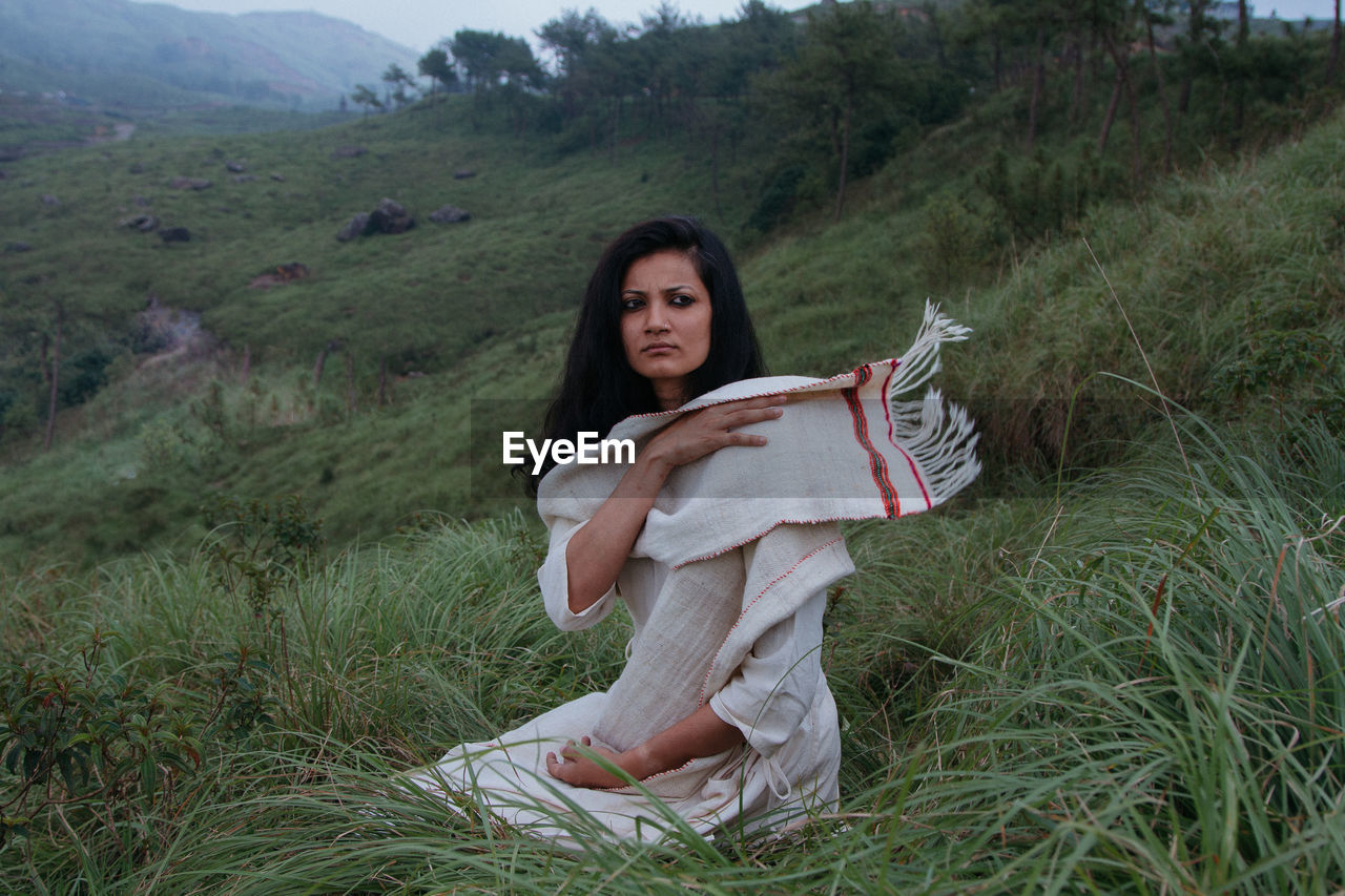 Portrait of young woman sitting on grass