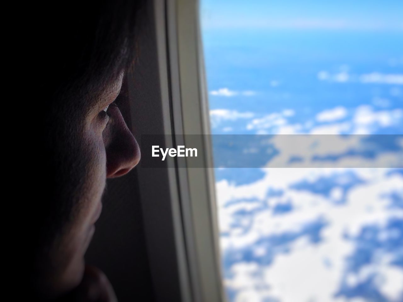 Woman looking through airplane window