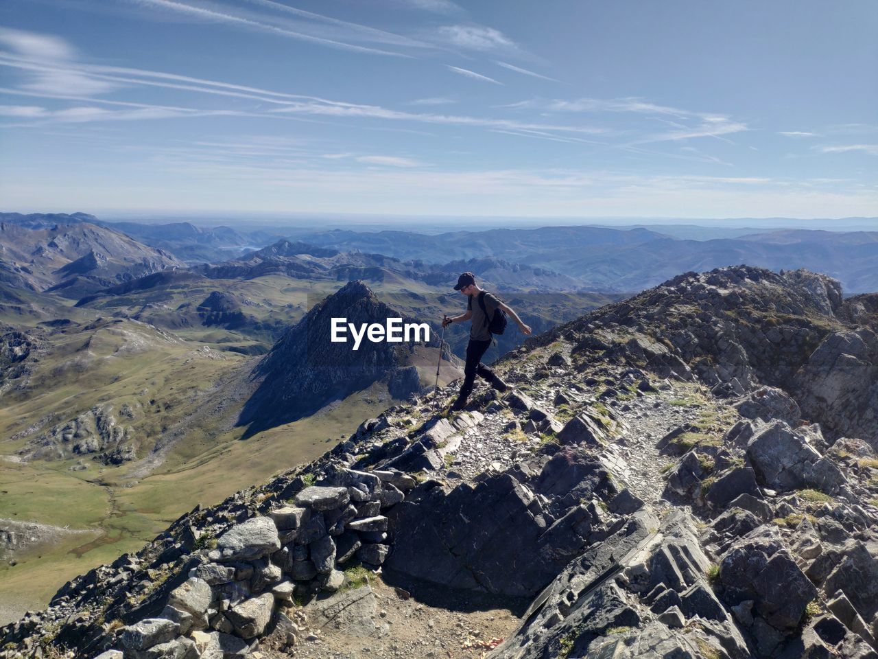 Side view of man walking on mountain against sky