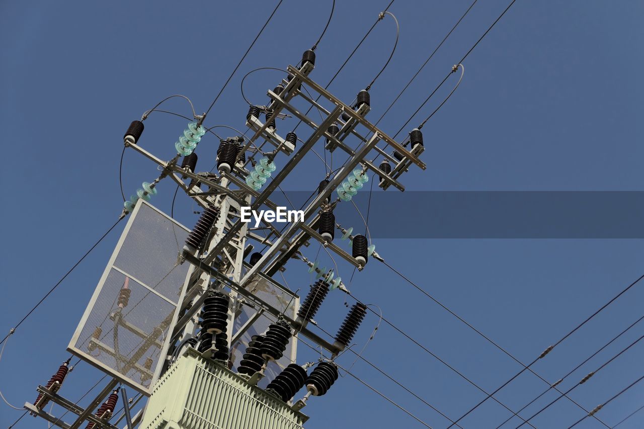 Low angle view of transformer against clear sky