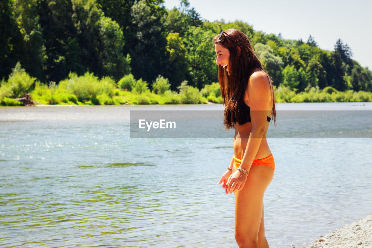 FULL LENGTH OF BEAUTIFUL WOMAN STANDING IN SEA