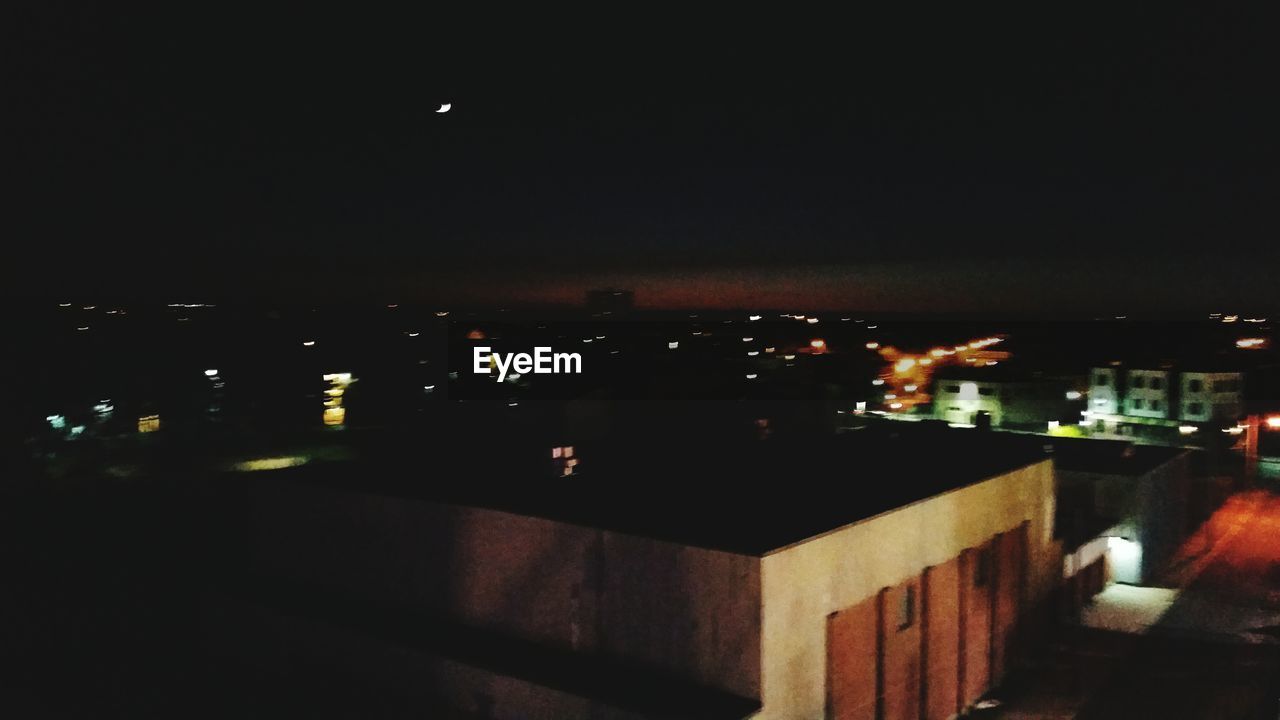 VIEW OF ILLUMINATED CITY AT NIGHT