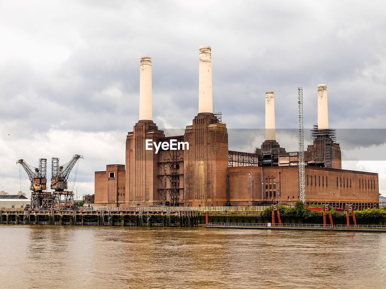 VIEW OF INDUSTRIAL BUILDING AGAINST CLOUDY SKY