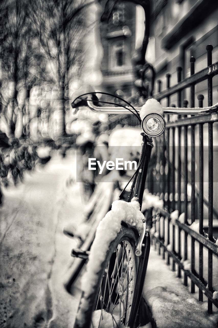 Close-up of bicycle parked against blurred background with snow in winter 