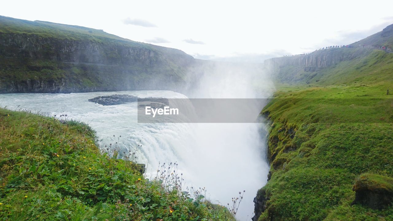 SCENIC VIEW OF WATERFALL AGAINST SKY