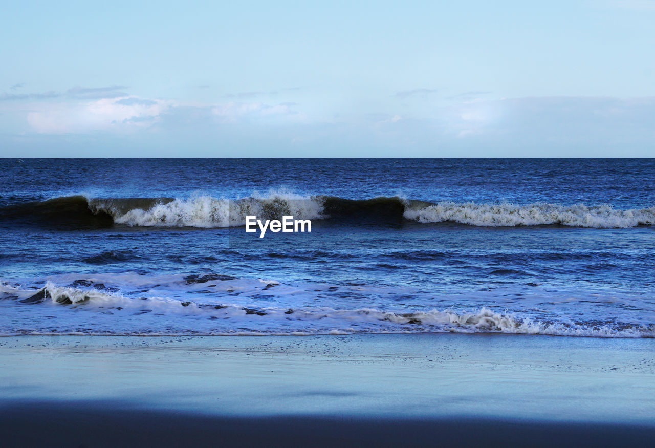 Scenic view of sea against cloudy sky