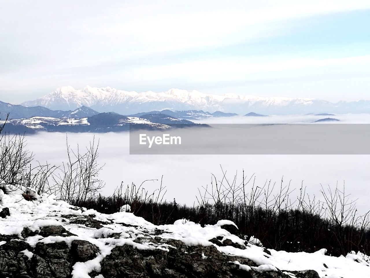SCENIC VIEW OF FROZEN LAKE AGAINST SNOWCAPPED MOUNTAINS