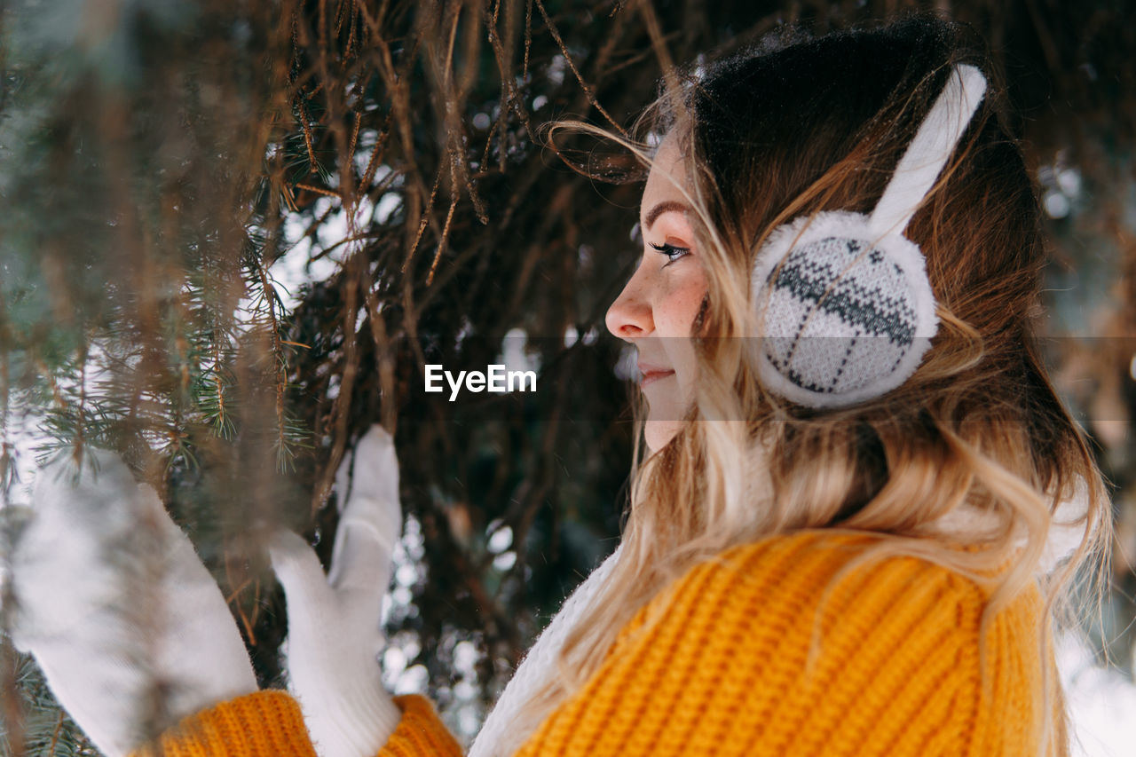 Teen blonde in a yellow sweater outside in winter. a teenage girl on a walk in winter clothes