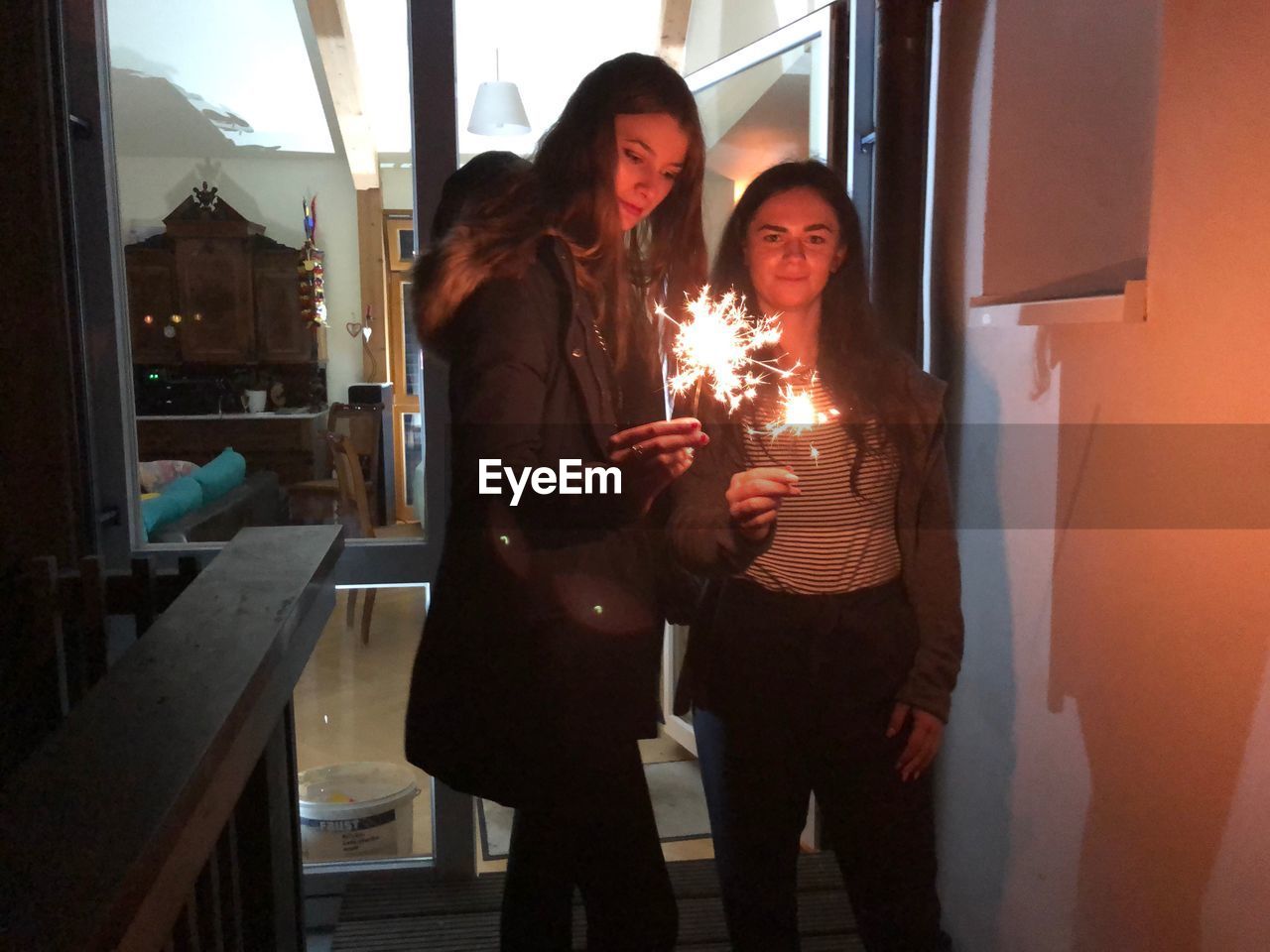 Siblings holding lit sparklers