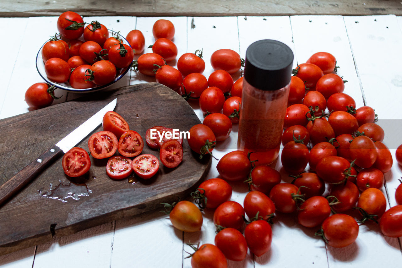 HIGH ANGLE VIEW OF TOMATOES ON CUTTING BOARD