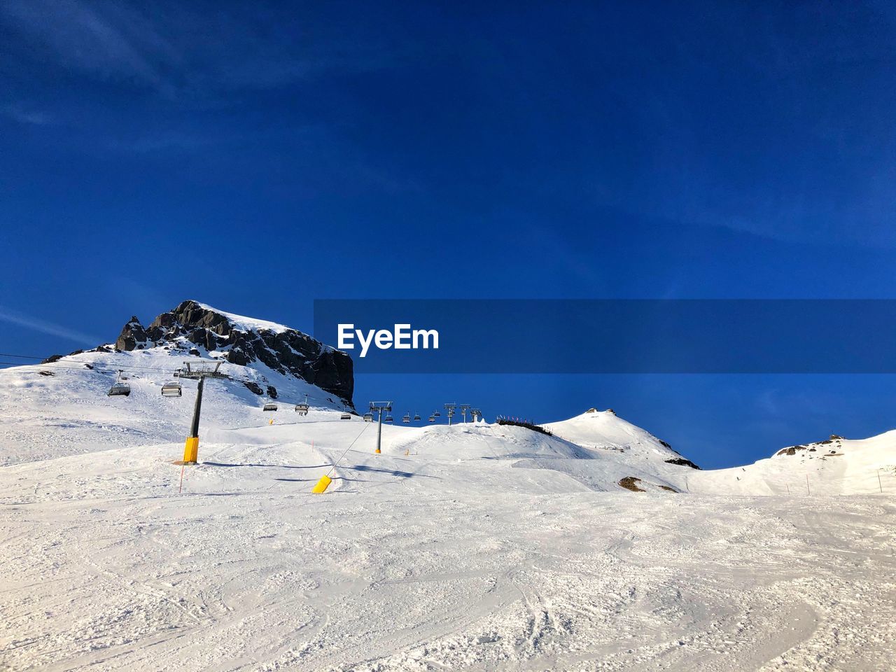 Scenic view of snowcapped mountains against blue sky