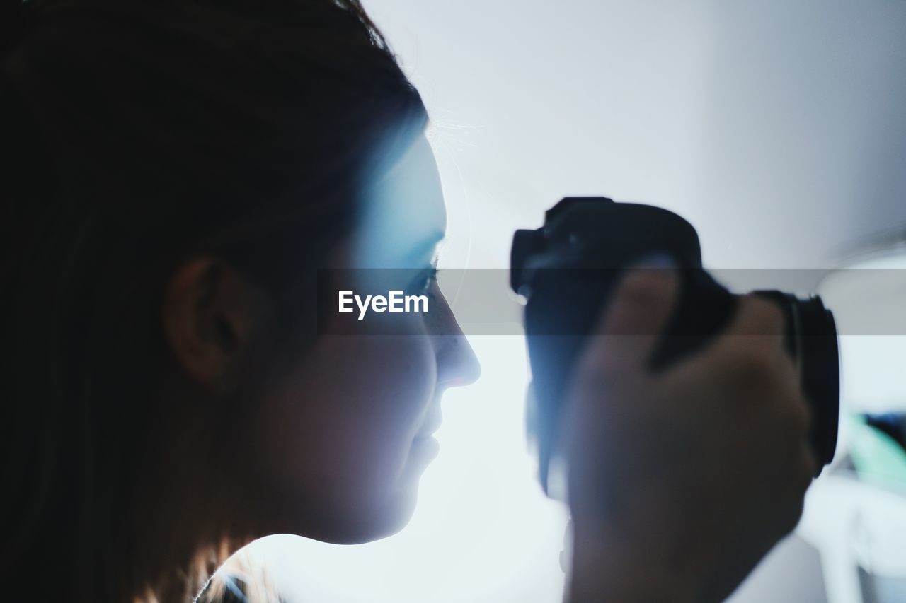 Close-up of woman photographing from camera while traveling in airplane