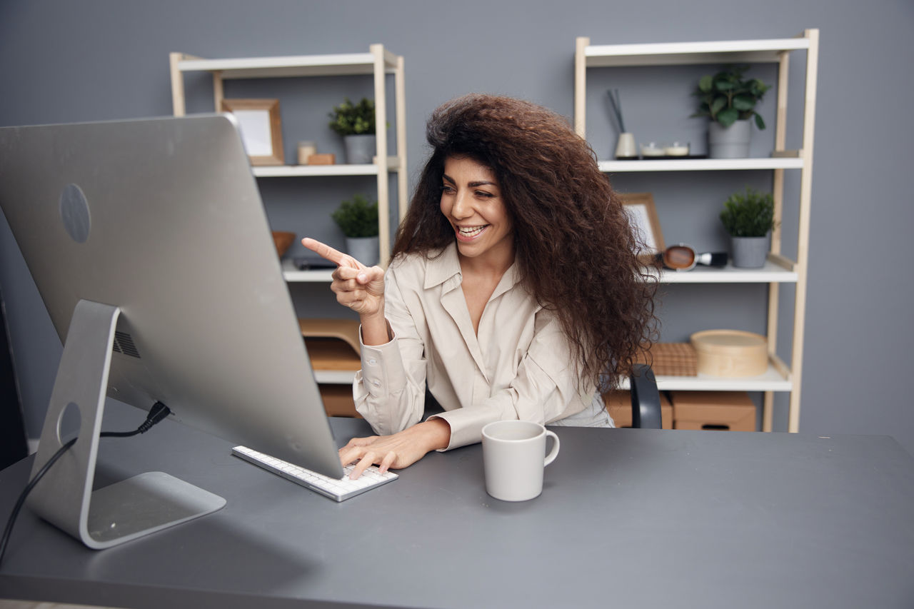 young woman using laptop while sitting on table