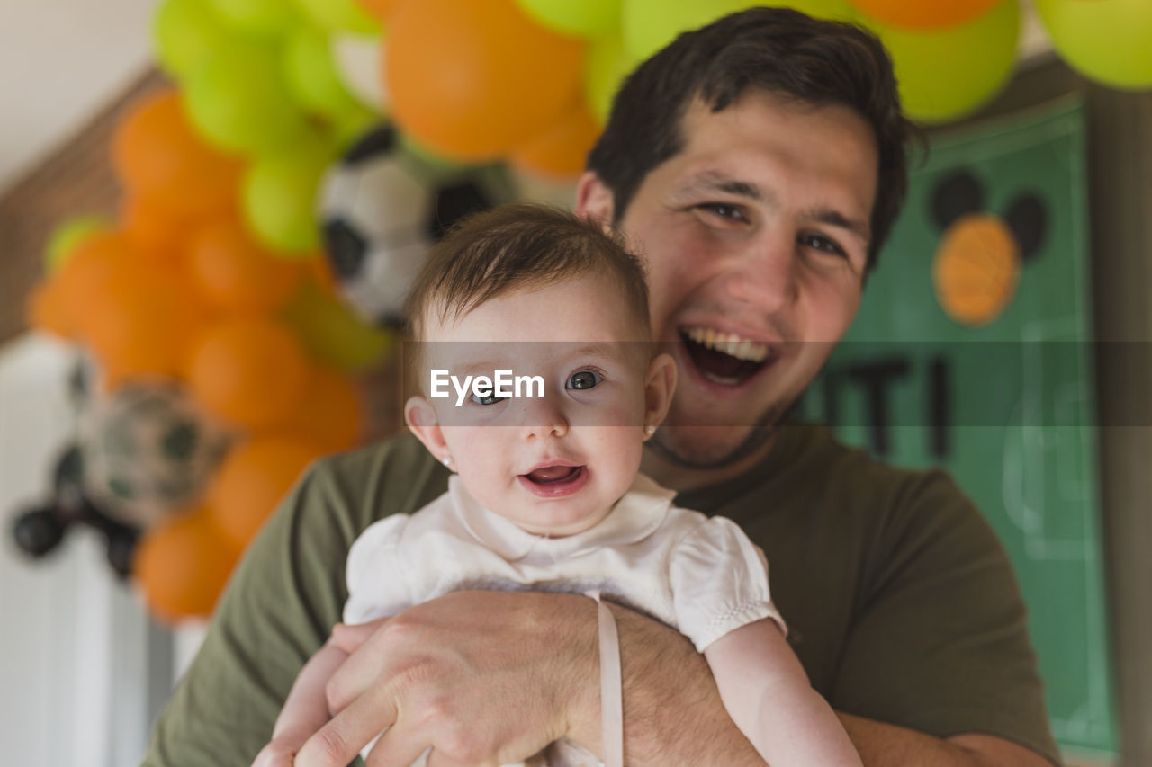 Portrait of father and cute baby smiling on birthday