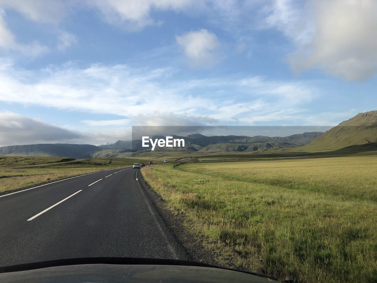 transportation, road, road trip, landscape, sky, cloud, environment, mountain, travel, mode of transportation, horizon, scenics - nature, nature, land, car, plain, motor vehicle, the way forward, vehicle interior, beauty in nature, highway, non-urban scene, journey, rural scene, no people, windshield, car interior, grass, field, rural area, prairie, mountain range, country road, day, vanishing point, transparent, infrastructure, travel destinations, on the move, plant, diminishing perspective, car point of view, glass, highland, outdoors, steppe, land vehicle, remote, tranquility, tranquil scene, motion, horizon over land, morning, symbol, road marking, freeway, tourism, marking, grassland, sign