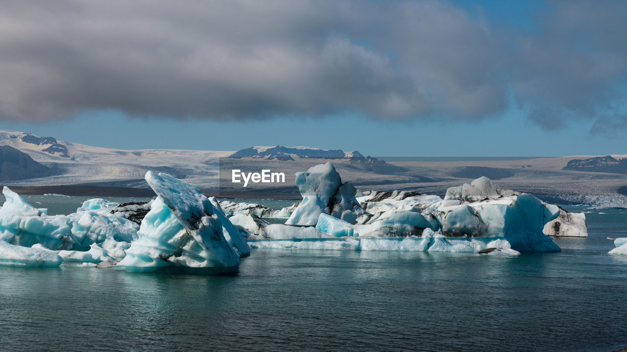 Panoramic view of frozen lake against cloudy sky