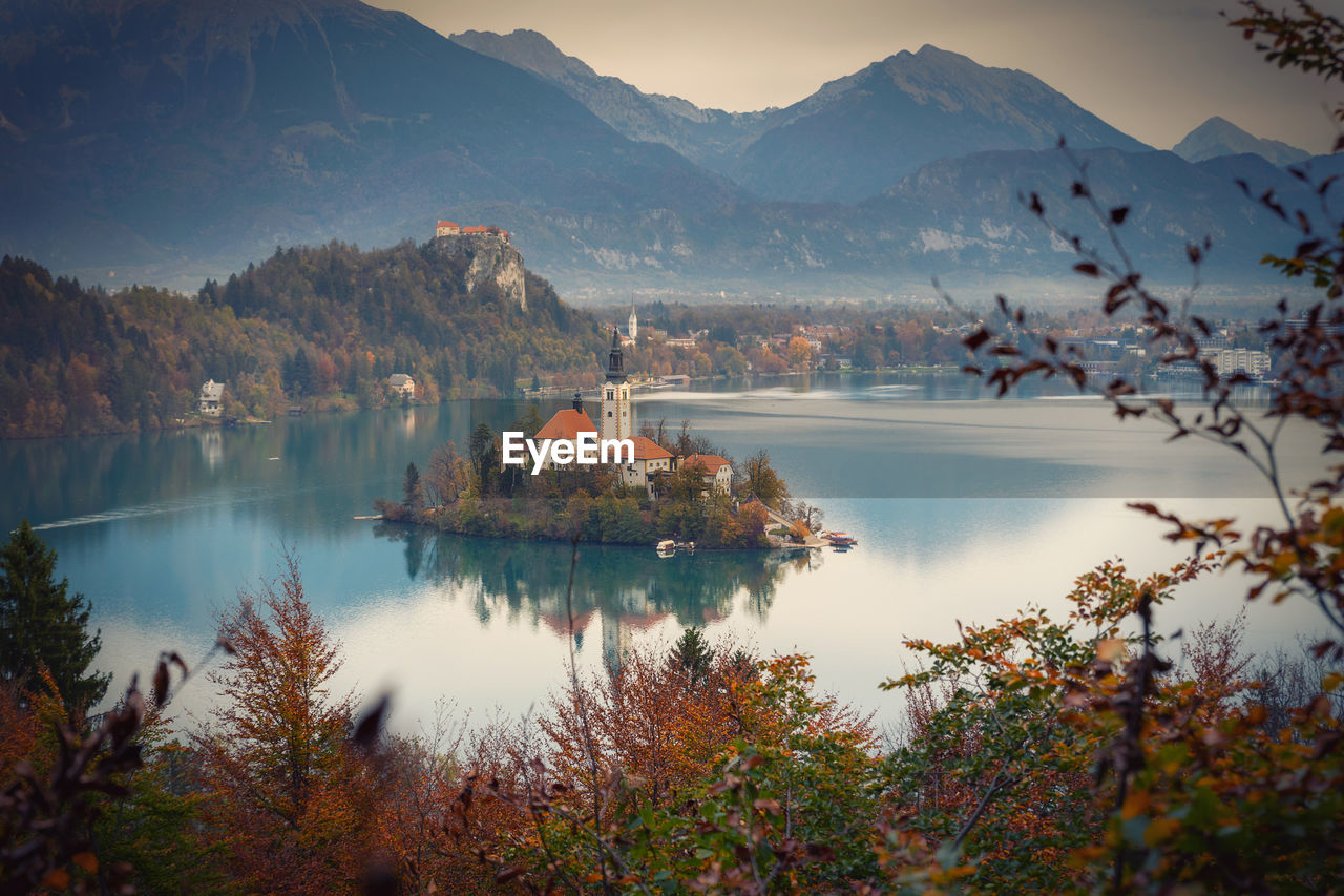 SCENIC VIEW OF LAKE BY TREES AGAINST MOUNTAINS