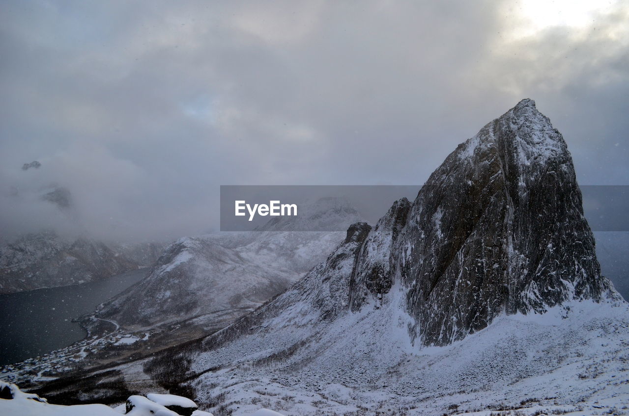 Beautiful rock covers with snowy clouds in minutes on senja region