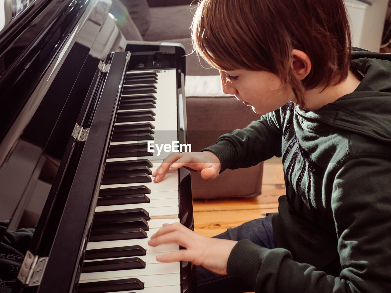 High angle view of boy playing piano at home